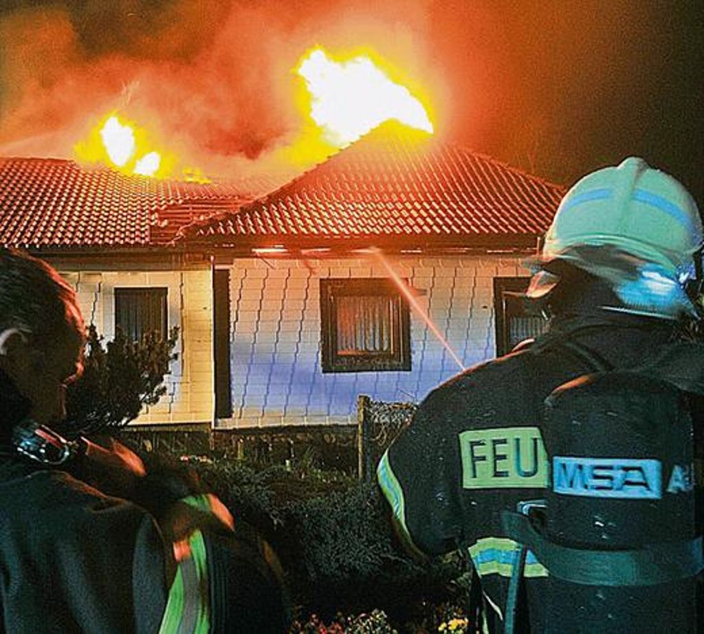 Haus brennt, Feuerwehr im Einsatz.